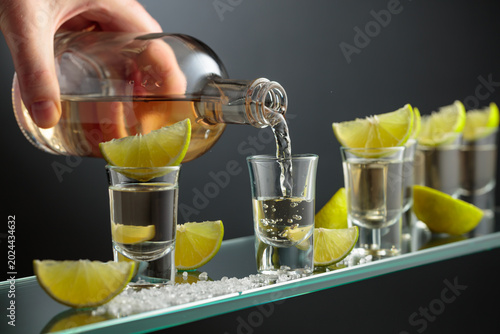 Tequila shots with salt and lime slices.
