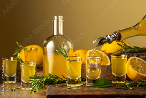 Tableau sur toile Italian liqueur Limoncello with fresh lemons and rosemary branches