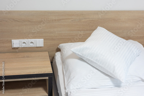 Detail of a hotel bed simply prepared for a guest. Horizontally.