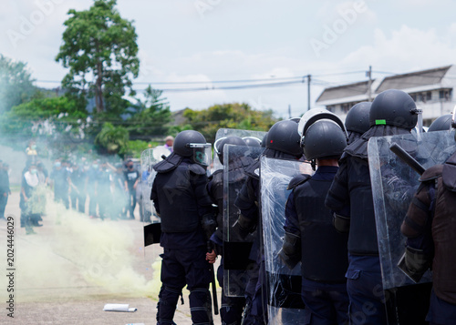 Obraz na plátně Riot police clashed with the protesters using smoke bombs