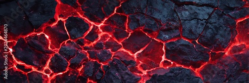 Molten lava and magma flowing through cracked black volcanic rock surface creating an intense thermal texture for geological and environmental concepts and natural science projects