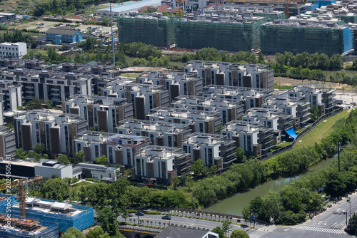 Fotografi Aerial view of a modern residential apartment complex next to a canal with ongoing urban construction in the background