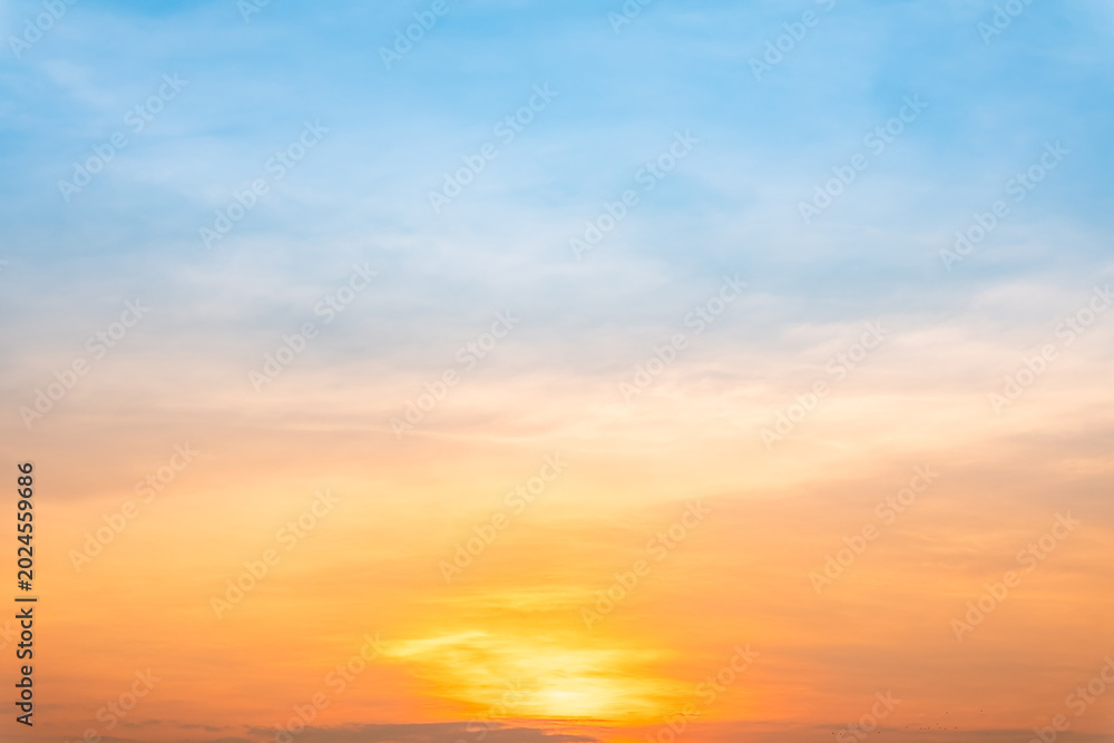 Fototapeta premium Sky sunset,Beautiful sunrise sky with vibrant gradient orange and gold colors and soft blue, Clear atmosphere with wispy clouds. Peaceful, perfect for background and copy space, High resolution images