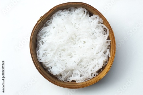 Foto top view of rice vermicelli in a wooden bowl isolated on white background