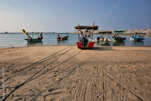 Bild auf Leinwand Vibrant fishing village boats protected by rock breakwater in Terengganu, Malays