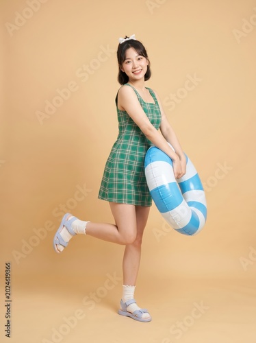 Happy girl holding a blue and white inflatable swim ring