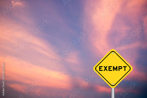 Obraz na płótnie Yellow transportation sign with word exempt on violet color sky background