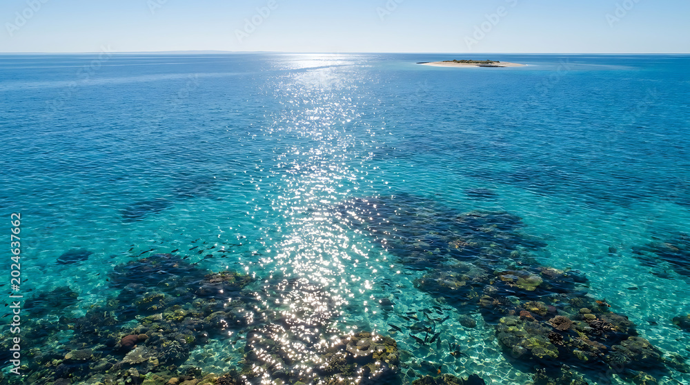 Fototapeta premium Brilliant Sunlight Reflecting Off Crystal Clear Turquoise Ocean Waters Near Tropical Island