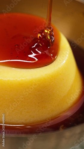 Pouring caramel sauce over flan pudding dessert close up Vertical Video