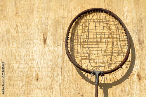 Old Rusty Badminton Racket on Wooden Background