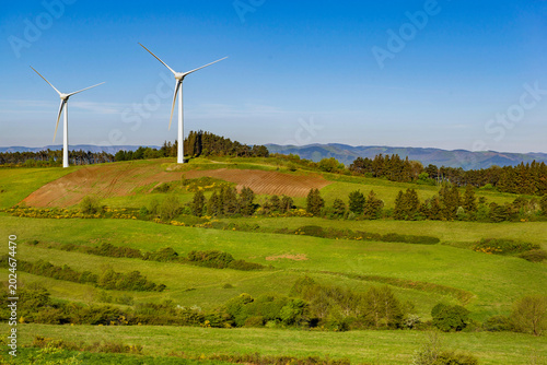 Canvas Print wind turbines  on hill under blue sky in greenery meadow in vaucluse french coun