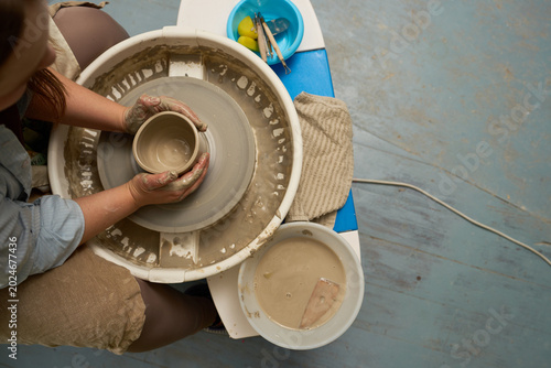 Schilderij op canvas Potter hands holding a misshapen clay vessel that collapsed during the throwing process