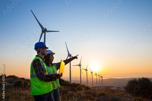 Canvastavla The engineers are reviewing data on a tablet, analyzing the performance of wind turbines in a field