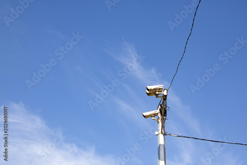 Photos CCTV cameras on a pole against a blue sky
