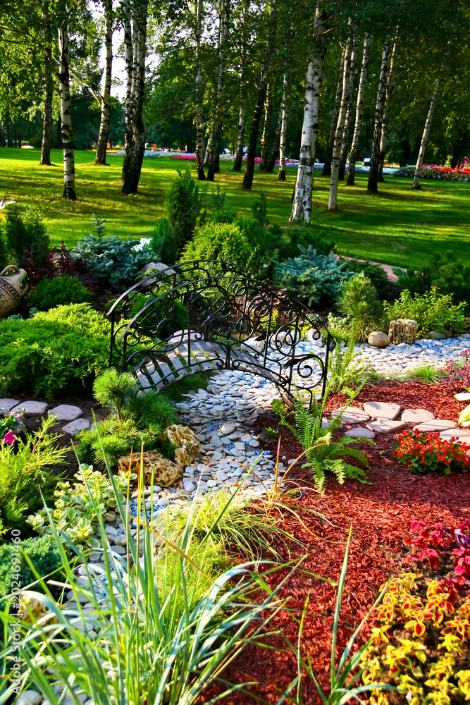 Obraz premium Serene Garden Landscape with Stone Path and Bridge Beneath Birch Trees