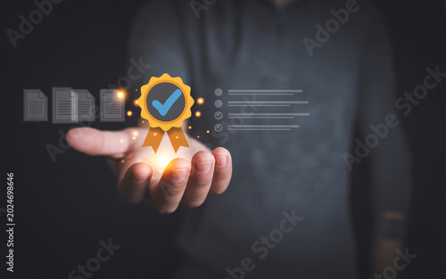 Hand holding a glowing golden badge with a checkmark, symbolizing quality assurance, certification, or guaranteed service.