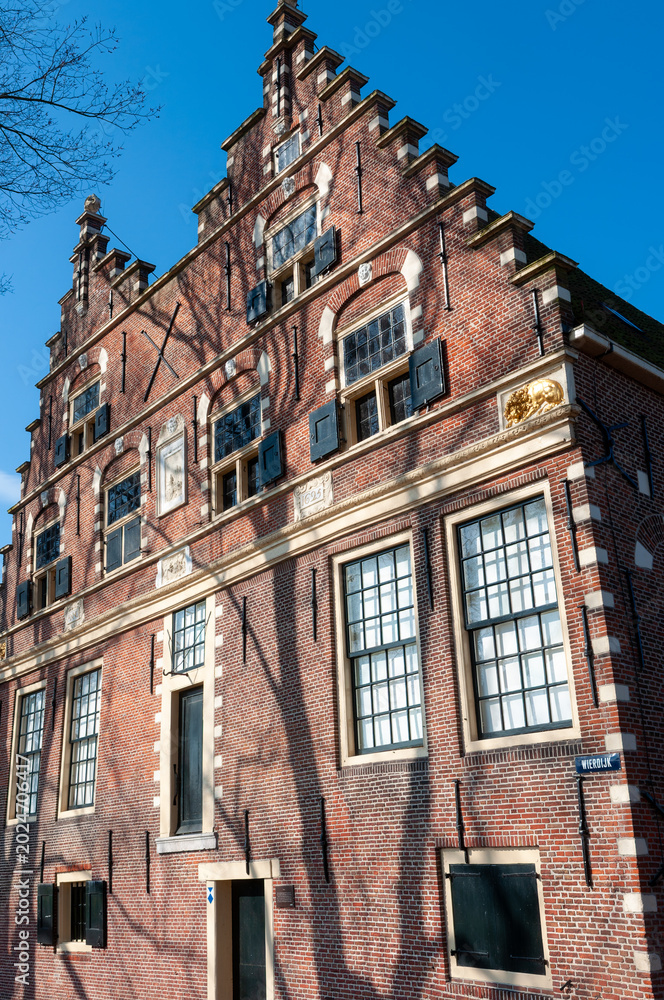 Obraz premium Historic brick building with large windows in a city under bright blue sky during daytime