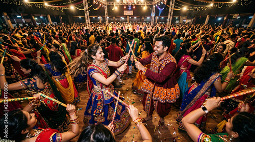 Colorful celebration with dancing couples during Indian festival event, participants dressed in traditional attire celebrate together with lights and musical vibes.