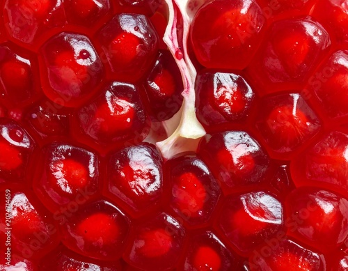 Close up of ripe pomegranate fruit with vibrant red seeds and textures