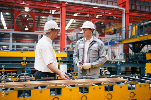 Senior manager and engineer discussing work in factory