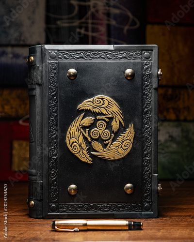 old black book with symbol with crows