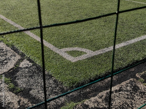 Framed Corner Kick Spot on Artificial Turf by Green Fence.