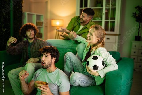 Friends watching exciting soccer game on television at home