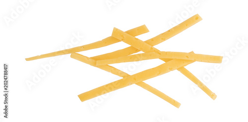 several thin strips of yellow hard cheese scattered on clean white background