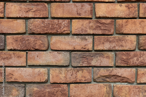 Bild auf Leinwand Textured rustic orange and brown brick wall surface close-up