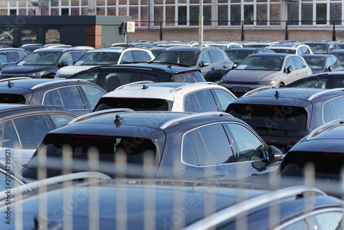 Large parking area filled with tightly packed used cars at a vehicle dealership site