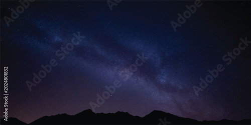Obraz na płótnie Silhouetted mountain range against a milky way galaxy at night with night sky ou