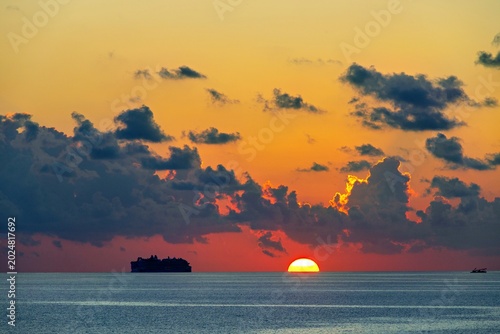 sunset over the caribbean sea with cruis ship silhouette