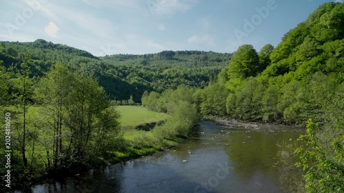 cenic Mountain River Flowing Through Green Valley and Forest Hills