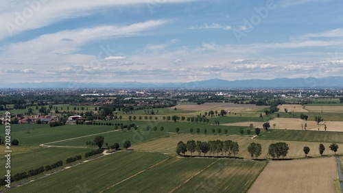 Fotografie Rural Italian Landscape: A sprawling aerial view showcases the patchwork of agricultural fields and scattered farmhouses of the Italian countryside