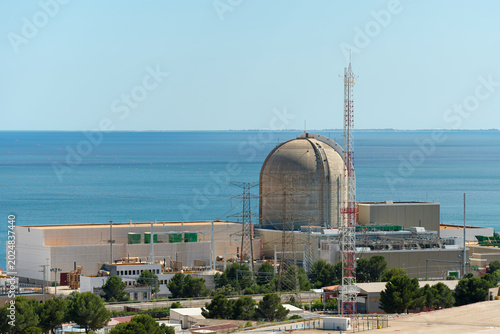 Obraz na płótnie Tarragona, Spain - May 16, 2026: Vandellos Nuclear Power Plant beside the Mediterranean Sea with reactor containment dome and coastal energy infrastructure under blue sky