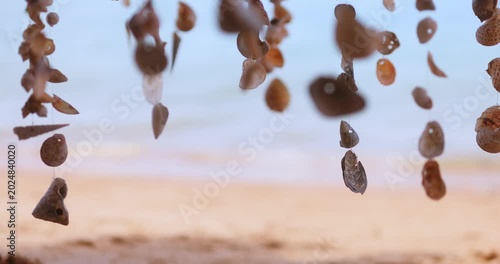 Seashell Wind Chimes Swaying Gently On Tropical Sandy Beach