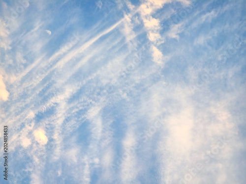 Sun shining through the puffy clouds. Beautiful sunny day. Background with clouds on blue sky. Dramatic with clouds on sunrise or sunset time. Natural sky. 