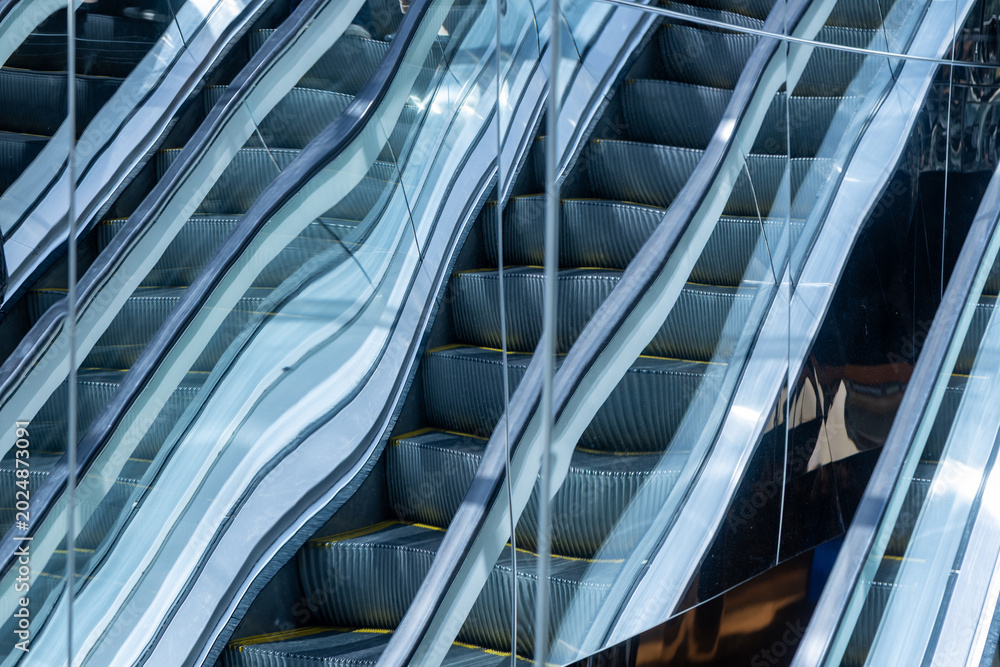 Fototapeta premium Abstract escalator reflection on mirrores building facade