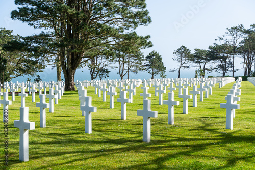 Military memorial cemetery in Normandy, France, with white crosses honoring American soldiers killed in battle during WWII