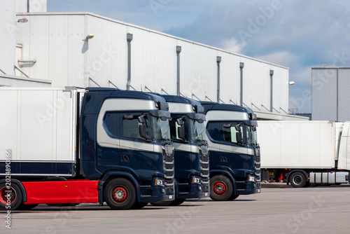 Fotografi Modern blue cargo truck delivery van parked logistics warehouse center complex building exterior bay