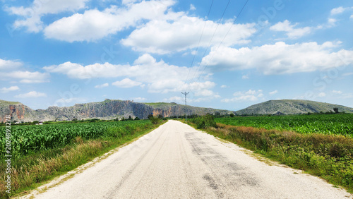 Foto The scenic road between Ayşehoca and Dilekkaya crosses the fertile Çukurova plains toward the towering limestone crags and medieval castle ruins of ancient Anavarza in Adana, Türkiye