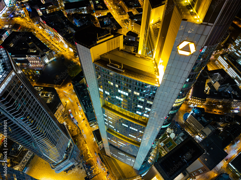 Naklejka premium High-angle view of the Commerzbank Tower illuminated at night in an urban setting