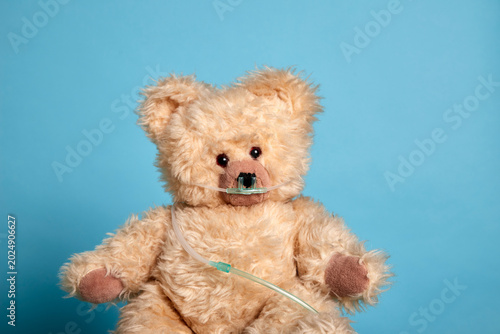 A teddy bear with an oxygen tube over its face, symbolising medical care for children and adults