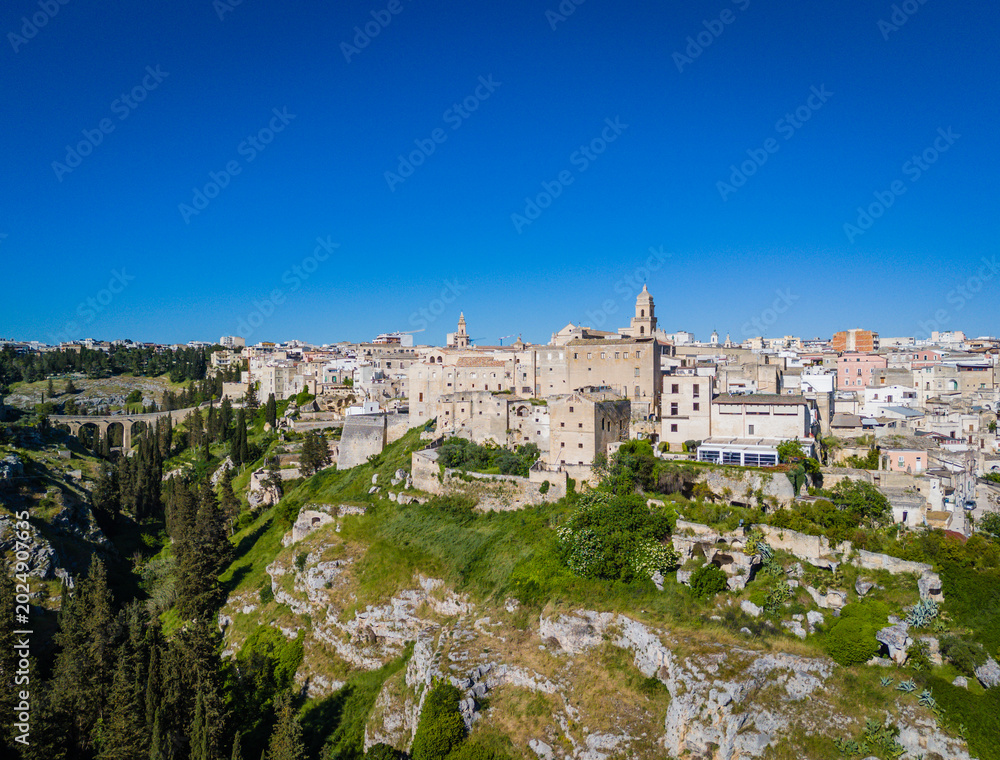 Naklejka premium Gravina in Puglia. Aerial drone panorama view of historic Italian townscape with Gravina di Matera river canyon landscape and Apulian architecture
