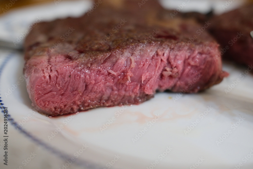 Fototapeta premium Medium rare ribeye steak, juicy cut close-up. Sliced medium rare rib eye steak showing juicy interior texture