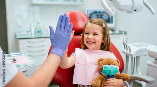 Happy child gives dentist a high five after a positive dental visit