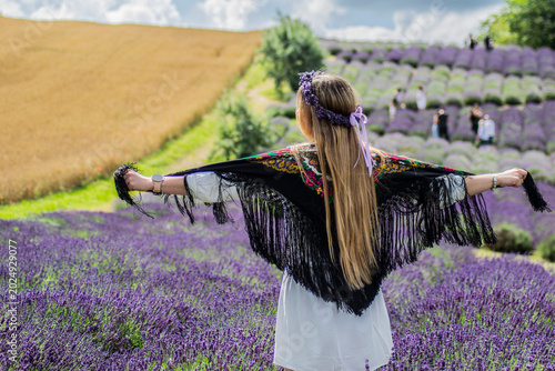 Obraz na płótnie Woman in lavender field wearing traditional floral shawl during summer countrysi