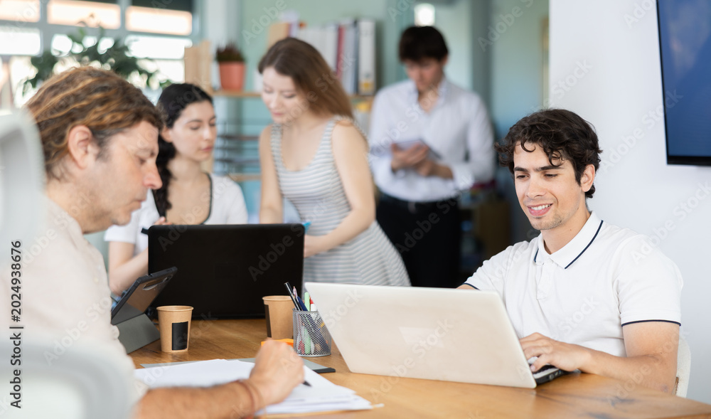 Fototapeta premium Several managers work together in a modern office. A well-coordinated management team