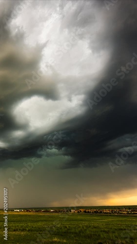 Turbulent storm clouds swirling overhead before heavy rainfall begins