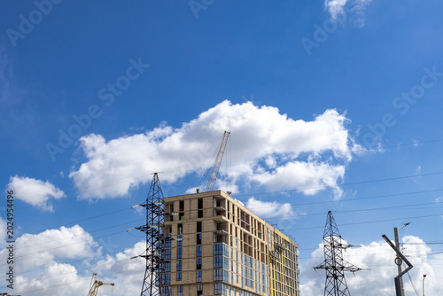 Canvastavla Construction of a Building Under a Clear Sky With Clouds and Power Lines in the